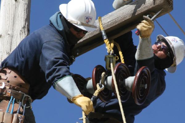 Navajo Tribal Utility Authority workers installing a distribution wire