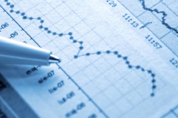 Close-up photo of a pen resting on a page of charts