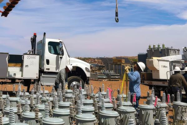 A crew from Provo Power works with NTUA during the Light Up Navajo initiative in 2025. An array of pole mount transformers is in the foreground.