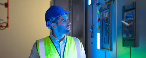 man in yellow vest looking at a glowing item