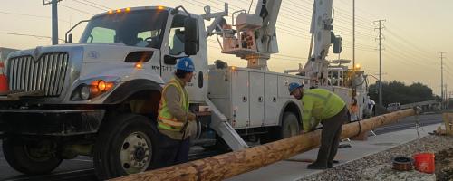 Austin Energy lineworkers setting up a new electrical pole