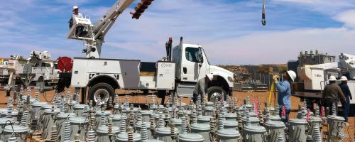 A crew from Provo Power works with NTUA during the Light Up Navajo initiative in 2025. An array of pole mount transformers is in the foreground.